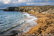 Des vagues puissantes déferlent sur la plage de port Bara située sur la côte sauvage de la presqu'île de Quiberon dans le Morbihan. Le sable est orange.