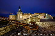 La ville close de Concarneau &agrave; l'heure bleue avec une ancre &agrave; l'avant-plan.