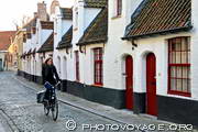 cycliste passant dans une petite rue bordée de Maisons-Dieu
