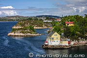 Pour arriver à Bergen par la mer, le ferry zigzague entre les îlots rocheux et les îles parsemées de maisons colorées.