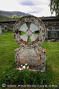 Pierre tombale avec une croix celtique particulière dans le cimetière qui entoure l'église en bois de Lom.