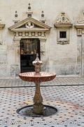 Petite cour attenante à la Salle des Colonnes dans la cathédrale de Séville. Une fontaine en marbre rose trône en son centre.