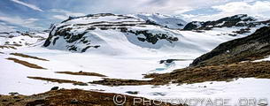 L'Aurlandsfjellet est parsemé de petits lacs tel que Andisvatnet qu'on devine à peine à la couleur bleutée de la glace. La route touristique Aurlandsvegen serpente entre les sommets de plus de 1600 mètres.