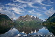 Reflet des montagnes de Hjelle dans le lac Oppstrynsvatnet sous un ciel chargé de cirrus floccus virga.