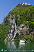 Cascade des 7 soeurs bordant le Geirangerfjord avec un ferry donnant l'échelle de grandeur.