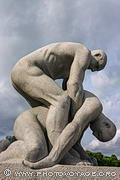 Homme soulevant le corps d'un autre homme. Sculpture en granit de Gustav Vigeland exposée sur l'escalier circulaire au pied du monolithe du Vigeland Park à Oslo.